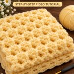 Folded yellow textured crochet blanket with raised interlocking lattice stitches